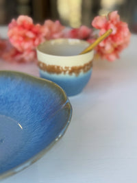 Ceramic bowls with a floral arrangement in the background