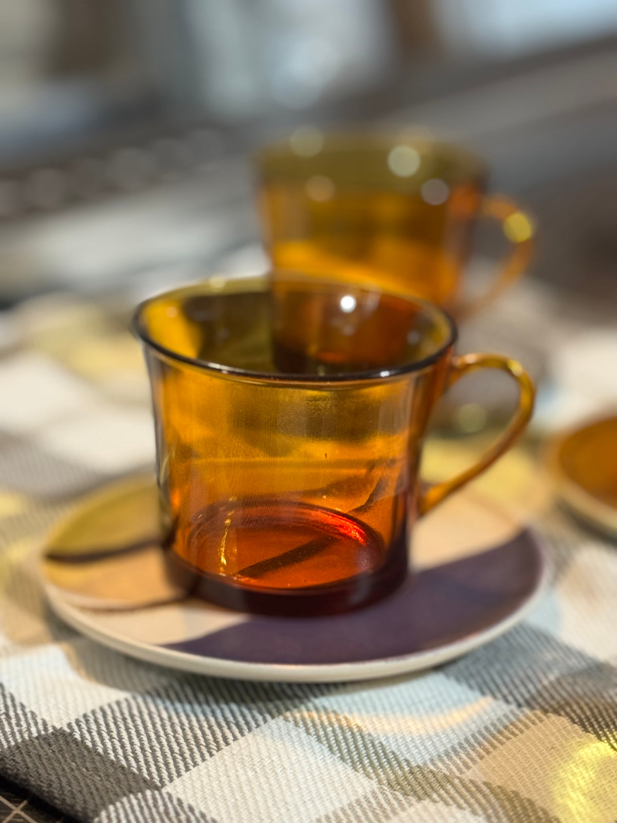 Amber glass mugs on a checkered tablecloth with a blurred background