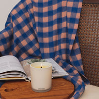 white glass vessel with burning hinoki lavender scented candle 