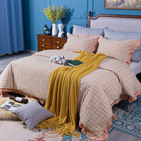 bedroom with blue wall and pink bedding with a yellow throw blanket