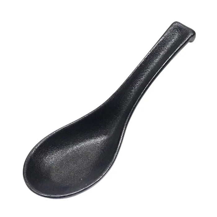 Black ceramic spoon on a white background