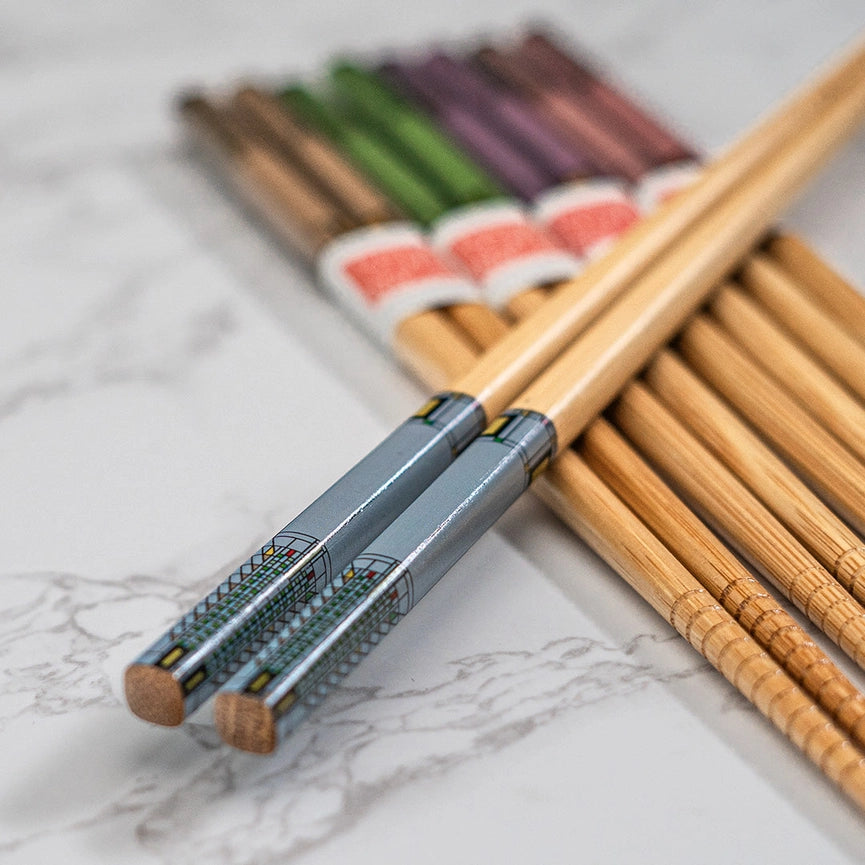 Set of wooden chopsticks with a metallic handle on a marble surface