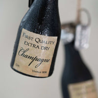Bottle of First Quality Extra Dry Champagne with a visible label.