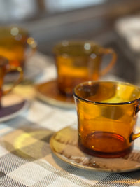 Amber glass cups on saucers with a blurred background