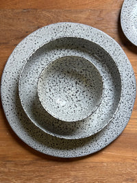 set of gray speckled plates on a wooden table
