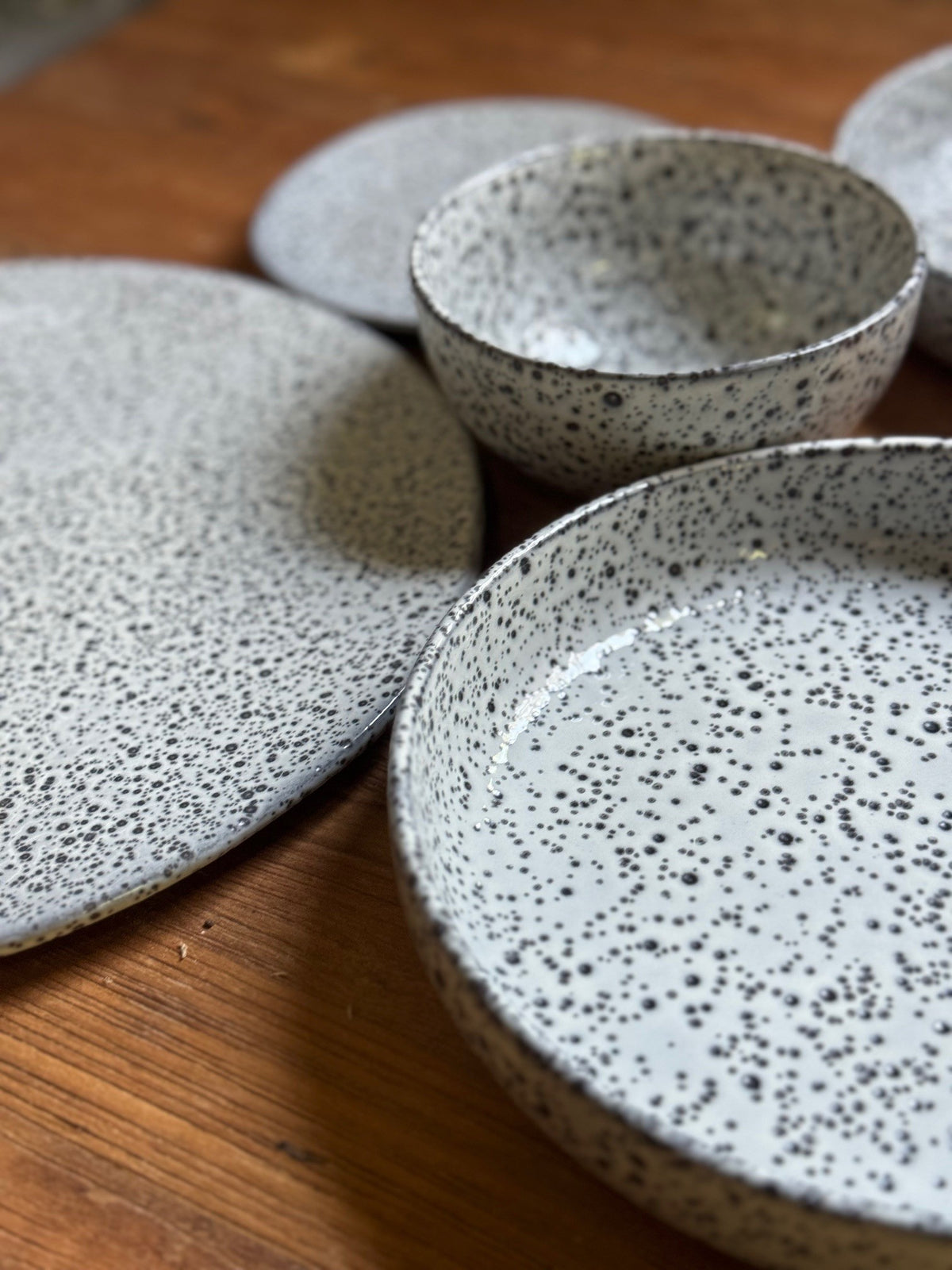 set of gray speckled plates on a wooden table
