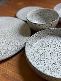 set of gray speckled plates on a wooden table