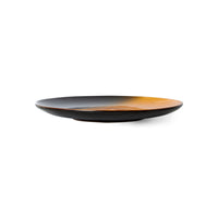 Black and orange ceramic plate on a white background