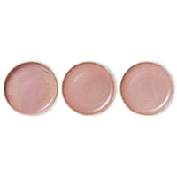 Three pink ceramic plates with gold rims on a white background