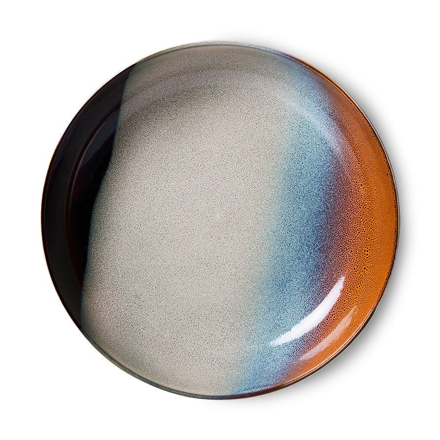 Round ceramic plate with gradient color from gray to orange on a white background