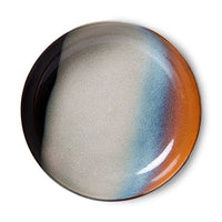 Round ceramic plate with gradient color from gray to orange on a white background