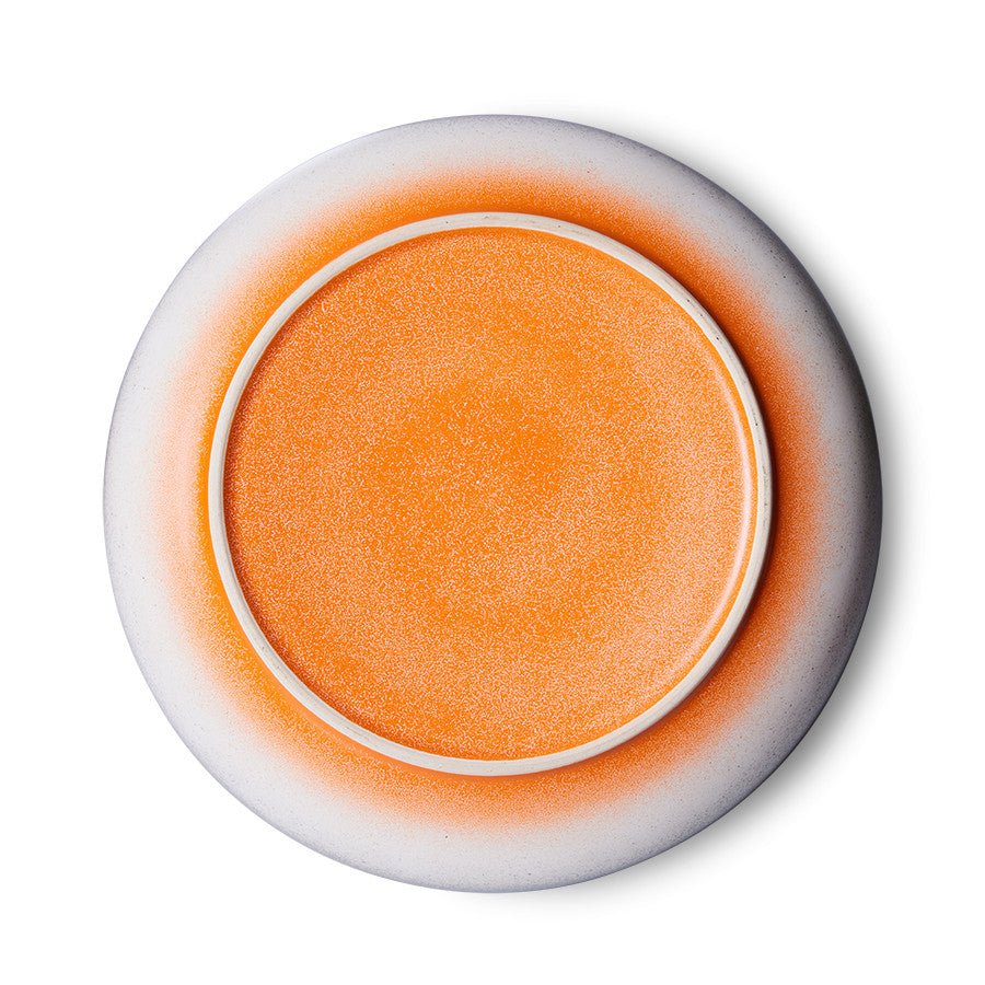 Round orange object with white rim on a white background