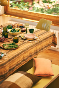 Dining table set with food and drinks in a cozy room with a window view.