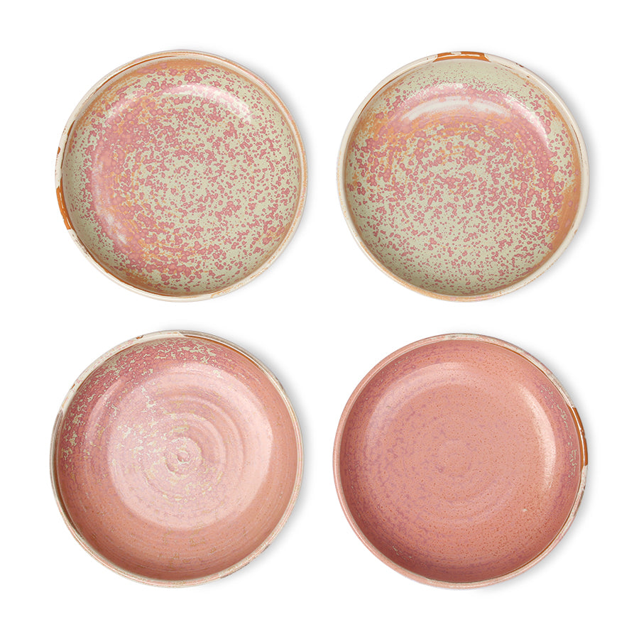 Four ceramic plates with speckled glaze on a white background