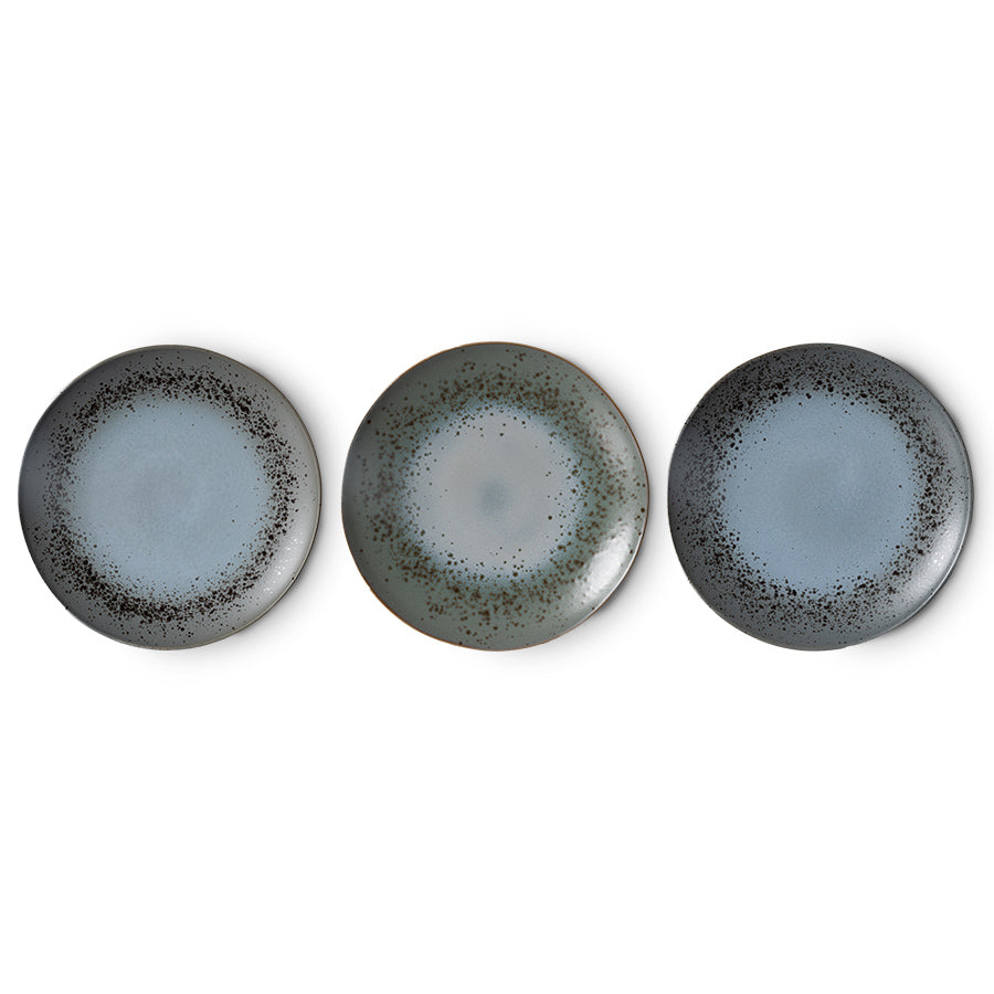 Three ceramic plates with a speckled design on a white background