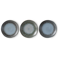 Three ceramic plates with a speckled design on a white background