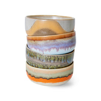 Stack of ceramic bowls with multicolored glaze on a white background