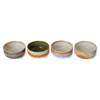 Four ceramic bowls with different color patterns on a white background