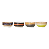 Four ceramic bowls with different color patterns on a white background