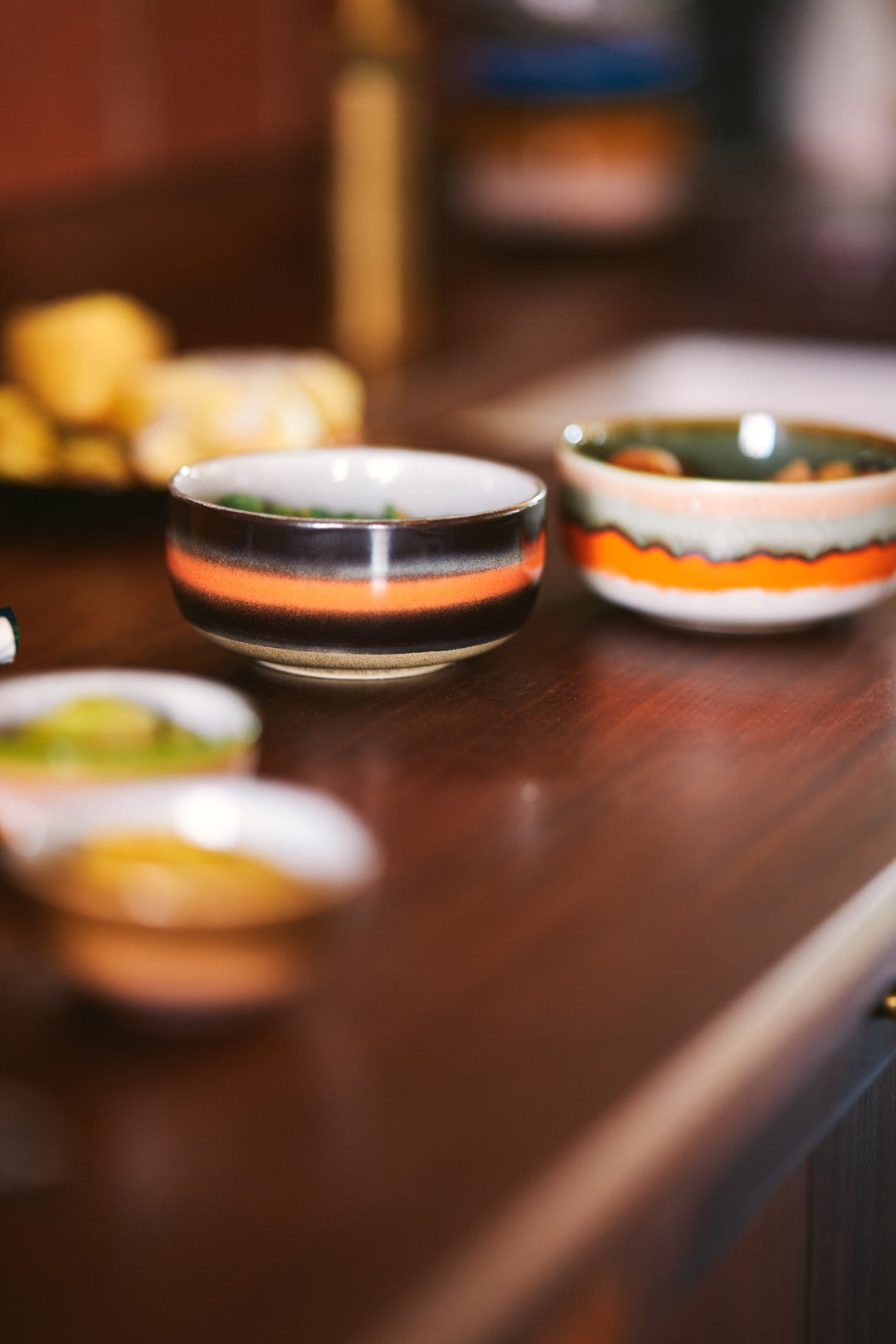 Two ceramic bowls with colorful patterns on a wooden surface.