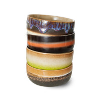 Stack of ceramic cups with multicolored glaze on a white background