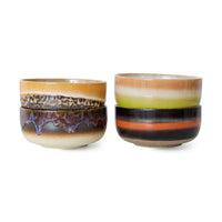 Two stacks of ceramic bowls with multicolored glaze on a white background