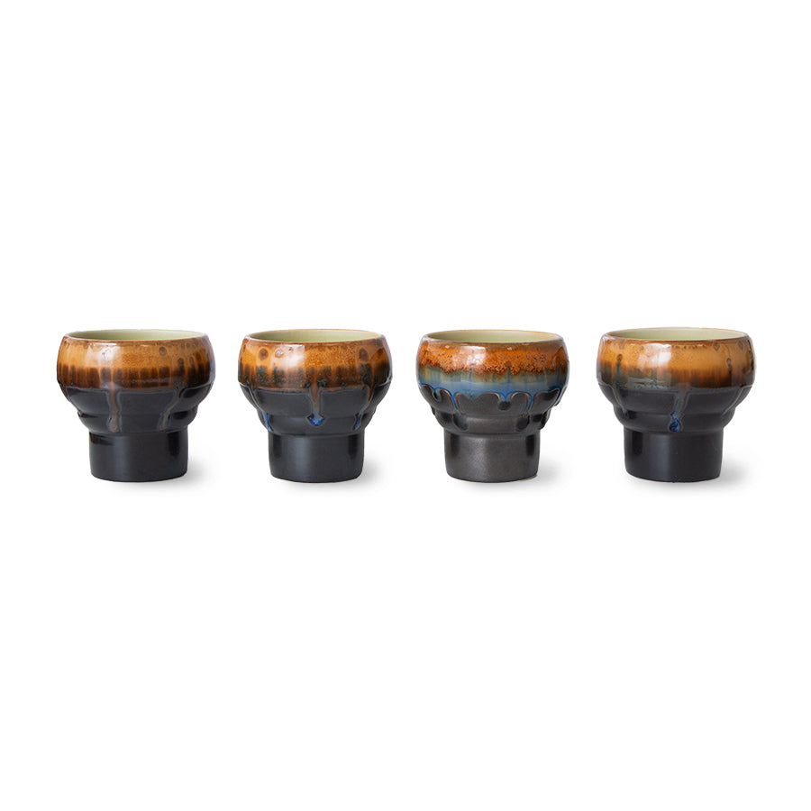 Set of four ceramic cups with brown and black glaze on a white background