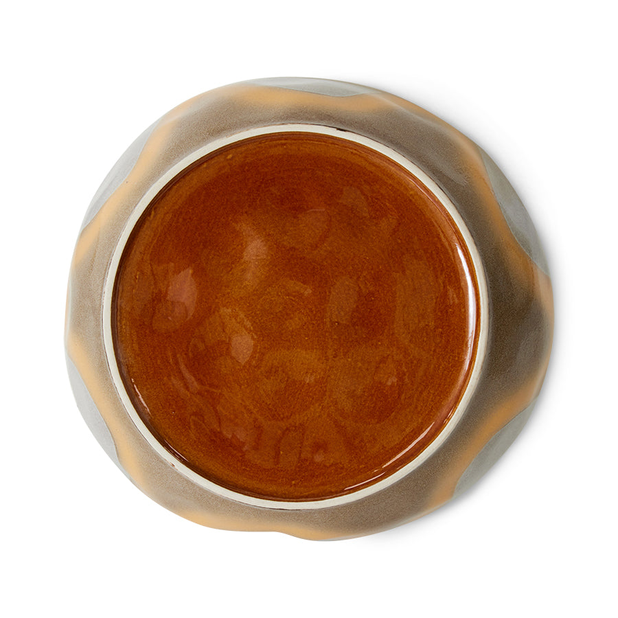 Brown bottom of pasta plate with metallic rim on a white background