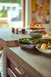 Kitchen counter with various dishes including a bowl of salad and a plate of food.