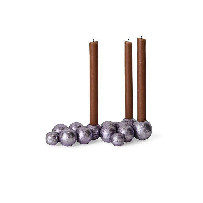 Candle holder with three brown candles on a white background