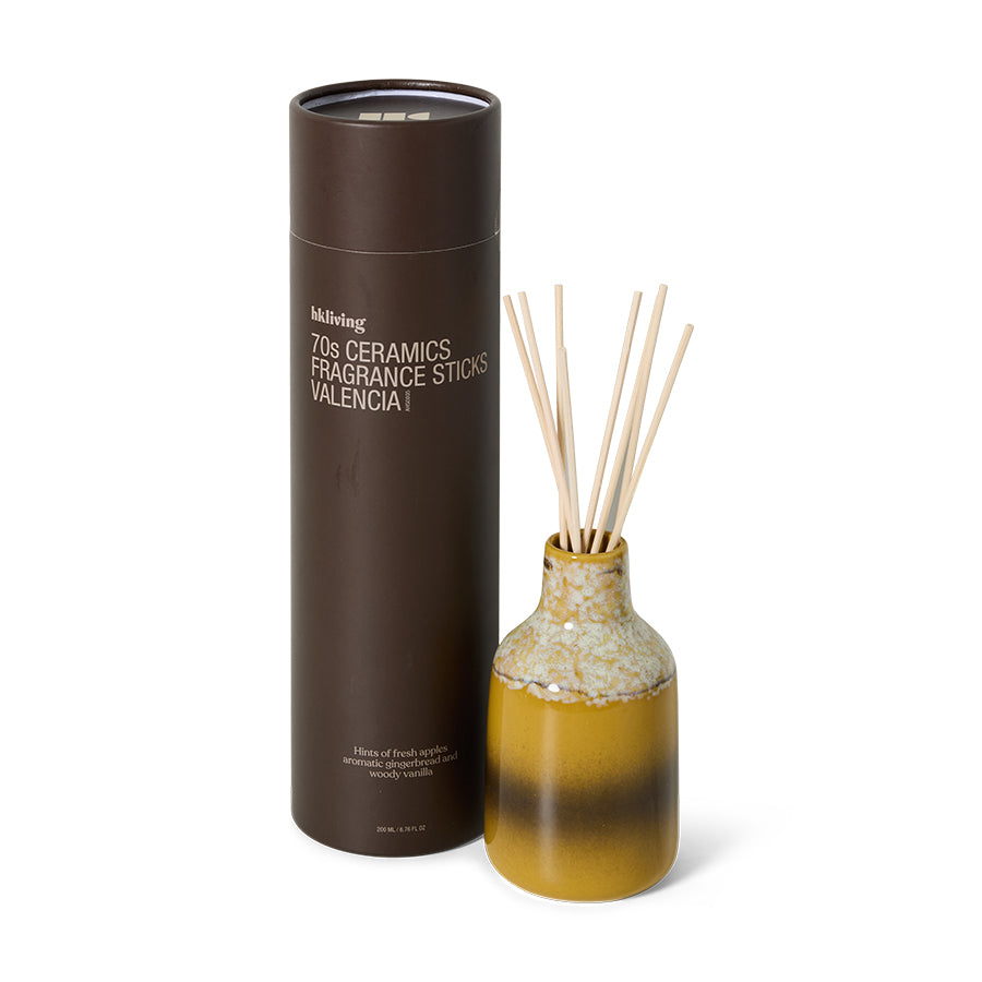 Fragrance sticks with a decorative bottle and cylindrical packaging on a white background