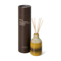 Fragrance sticks with a decorative bottle and cylindrical packaging on a white background