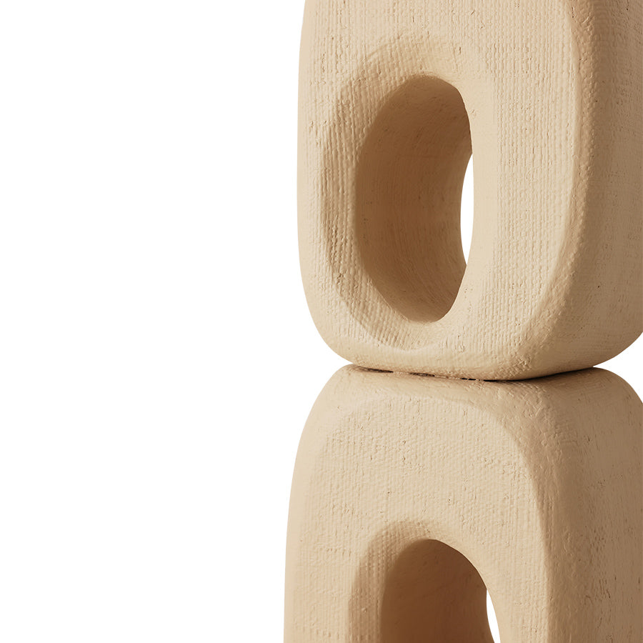 Beige ceramic block with a central hole on a white background