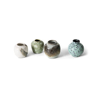Four ceramic vases with different textures and colors on a white background