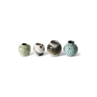 Four small ceramic vases with speckled glaze on a white background