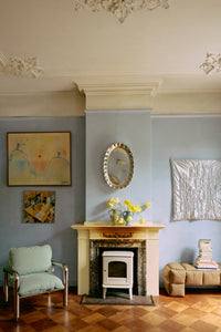 Living room with fireplace, artwork on the wall, and a chair.