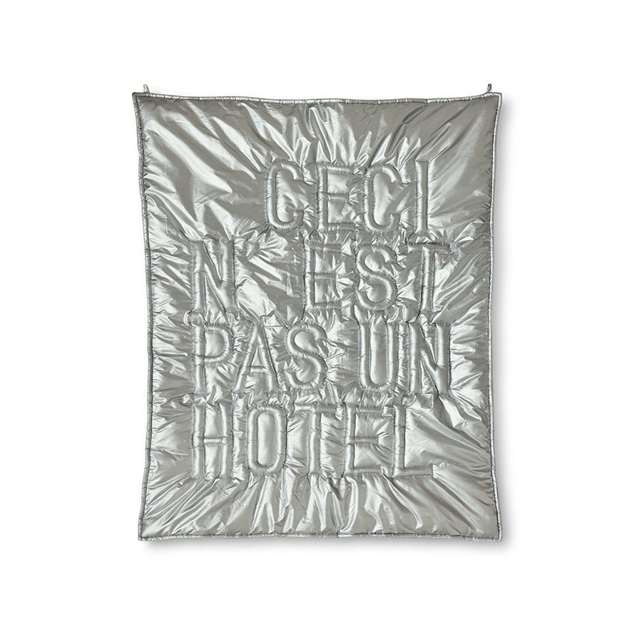 Silver quilt with text on a white background