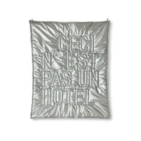 Silver quilt with text on a white background