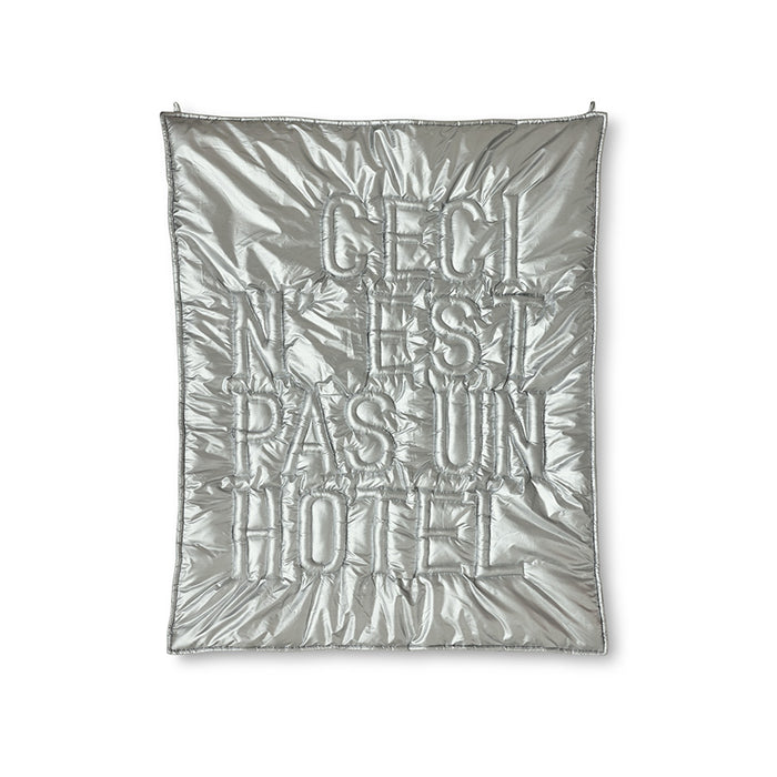 Silver quilt with text on a white background