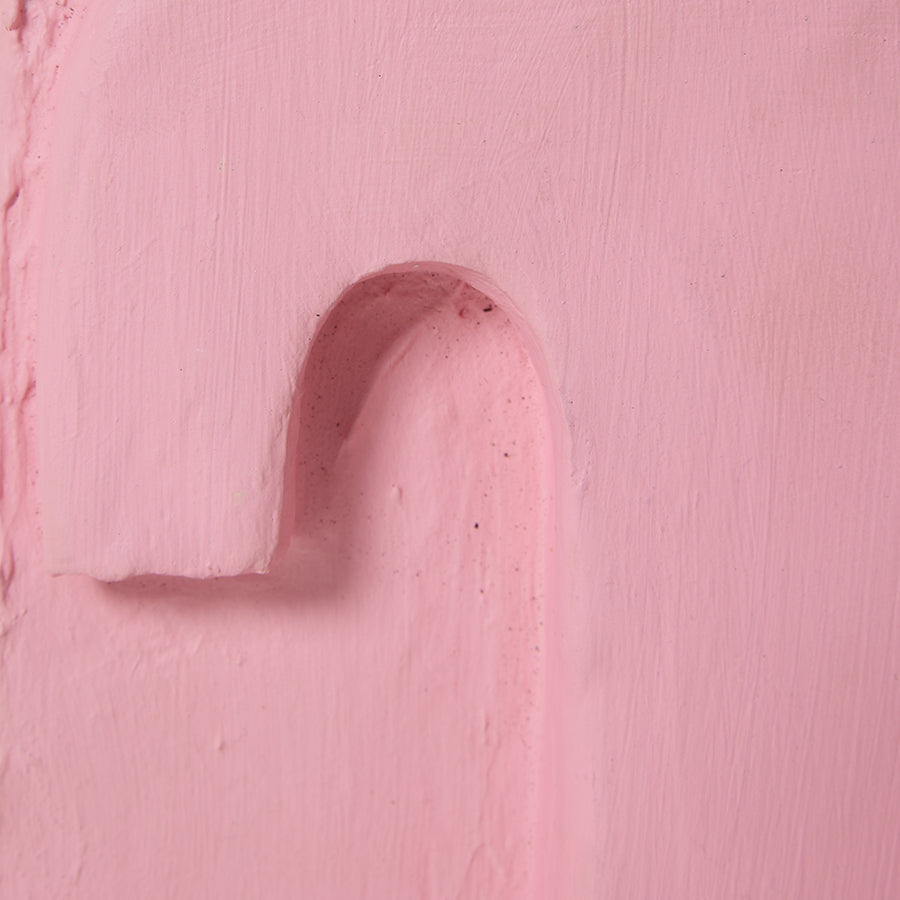 Close-up of a pink textured surface with a heart shape cutout.