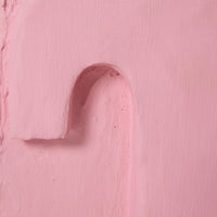 Close-up of a pink textured surface with a heart shape cutout.