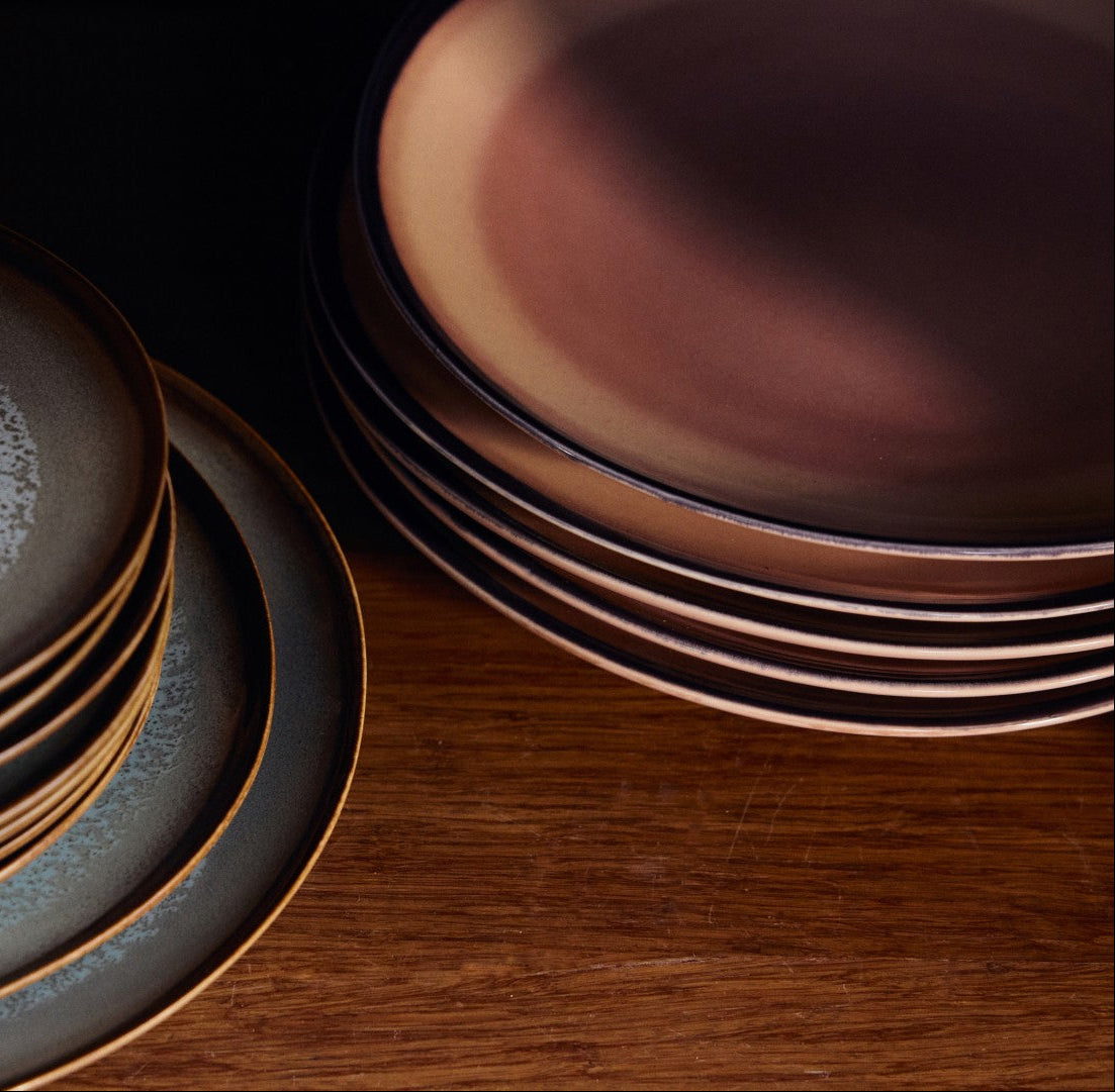 Stacks of ceramic plates on a wooden surface