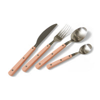 Set of cutlery with pink handles on a white background