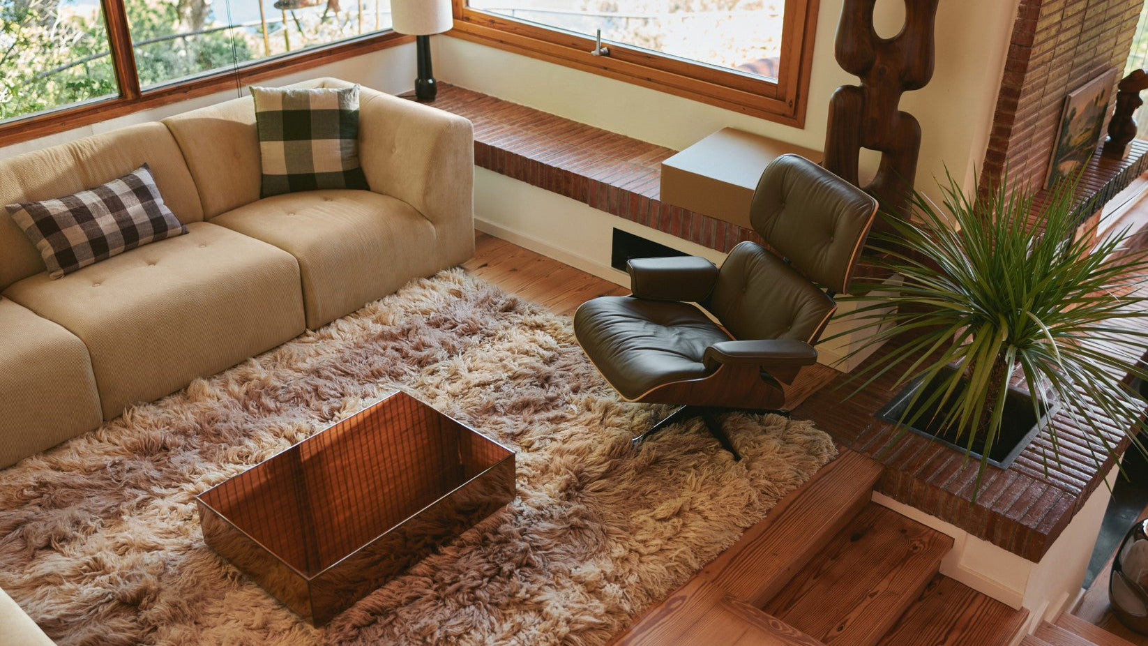 Living room with beige sectional sofa, brown armchair, and wooden coffee table.
