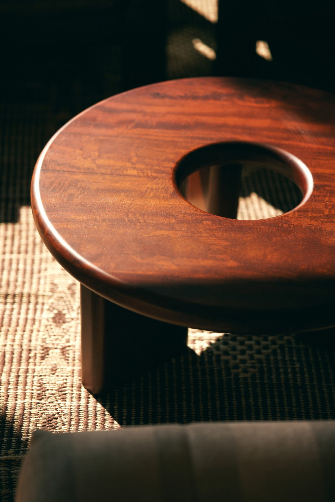 Wooden stool with a circular hole on a textured surface