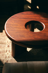 Wooden stool with a circular hole on a textured surface
