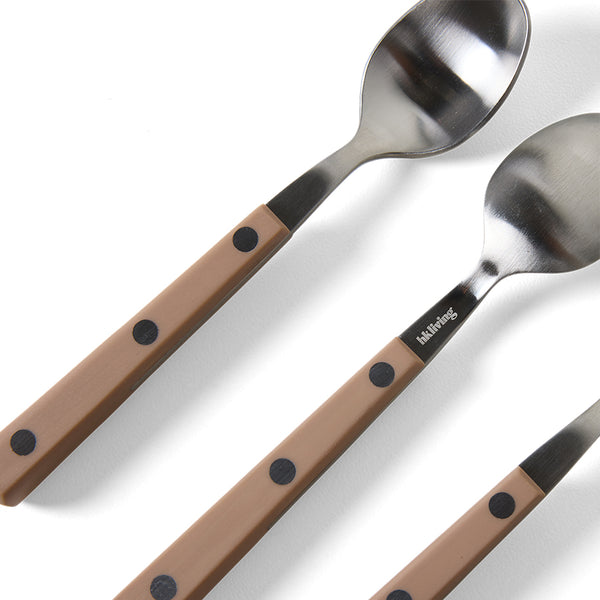 Two spoons with brown handles and black dots on a white background