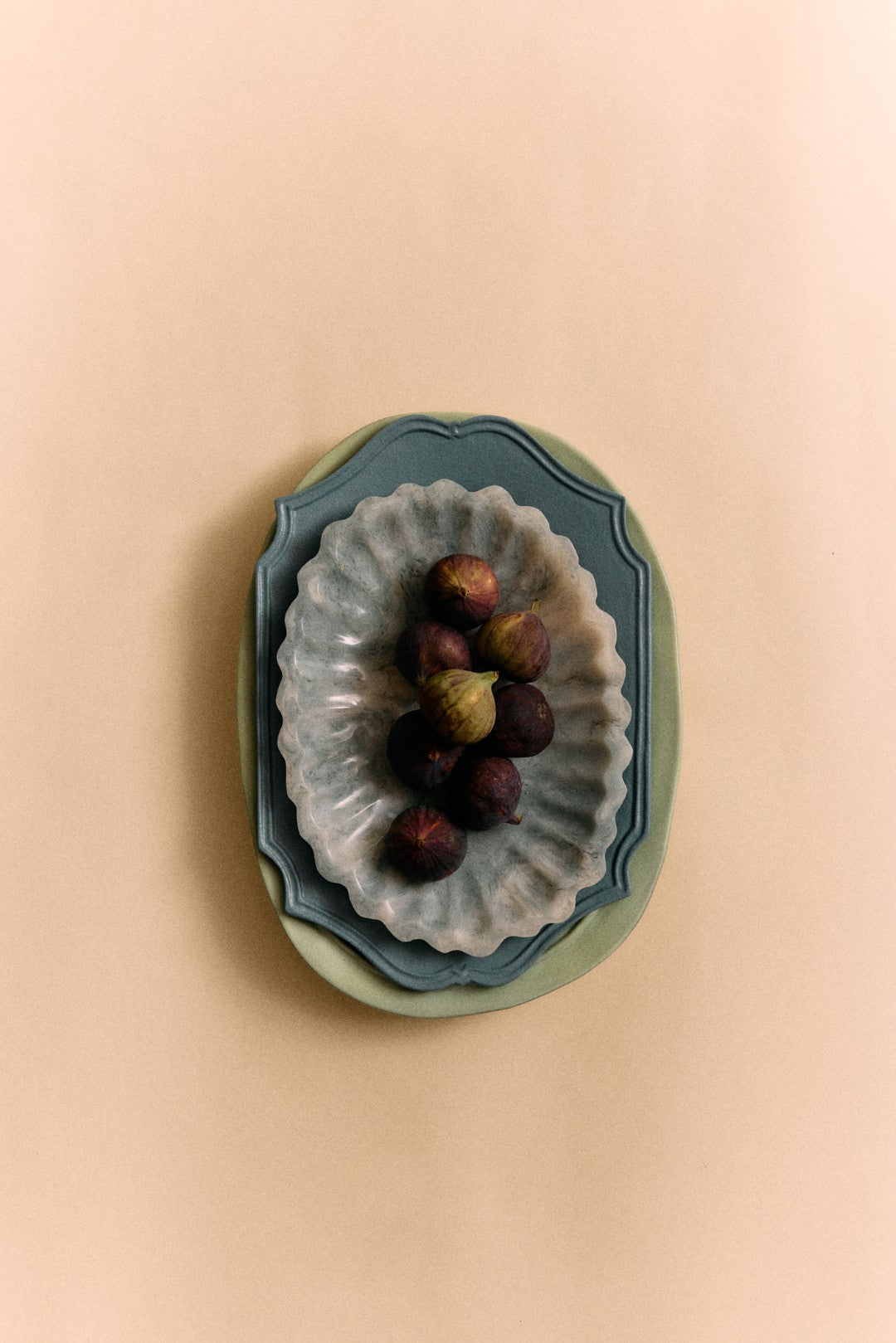 Decorative wall art with a scalloped edge and small figurines on a beige background