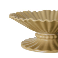Beige ceramic dish with scalloped edge on a white background