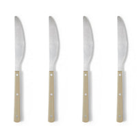 Four knives with beige handles on a white background